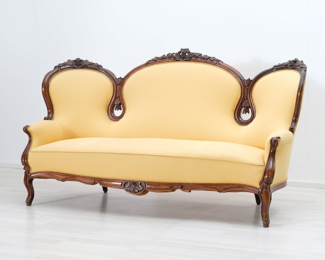 Antiikkinen sohva keltaisella verhoilulla