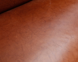 Puurunkoinen sohva nahkaverhoilulla ruskea